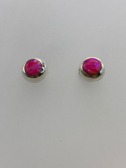 Detalle lateral de los aretes mostrando el engaste a mano y la profundidad del color rosa
