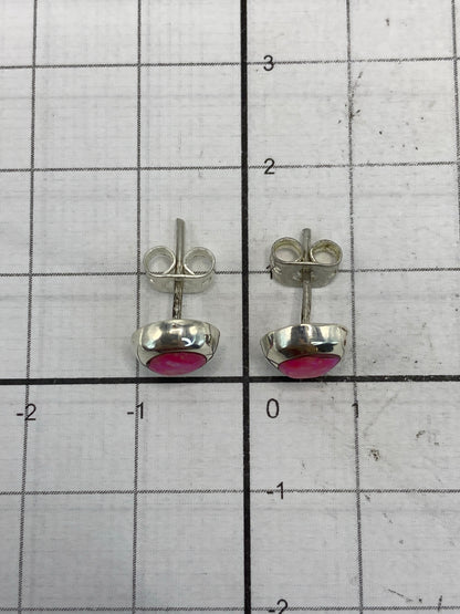 Aretes en la balanza de joyería mostrando 1.0 gramo de peso total