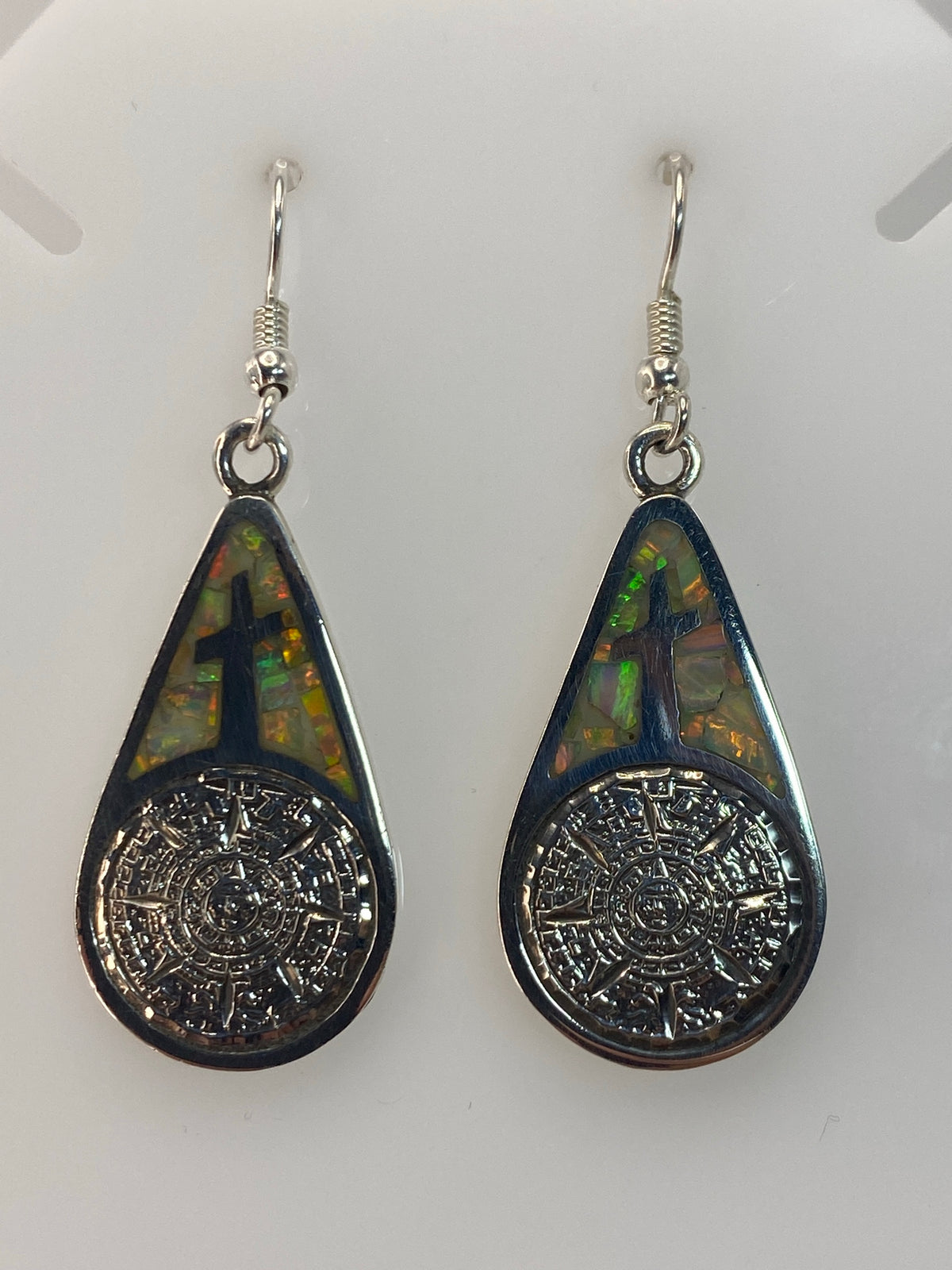 Aretes colgando mostrando el largo de 5 cm y el diseno completo de la cruz