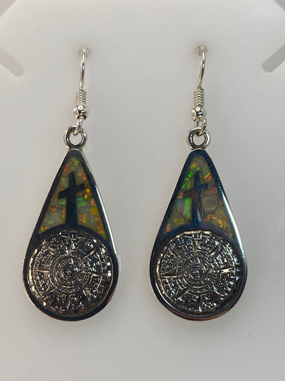 Aretes colgando mostrando el largo de 5 cm y el diseno completo de la cruz
