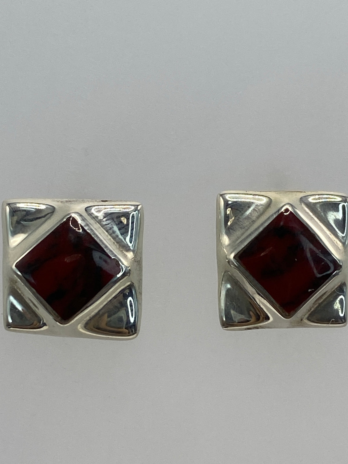 Aretes geométricos con incrustación de piedra, mostrando el Quinto 925