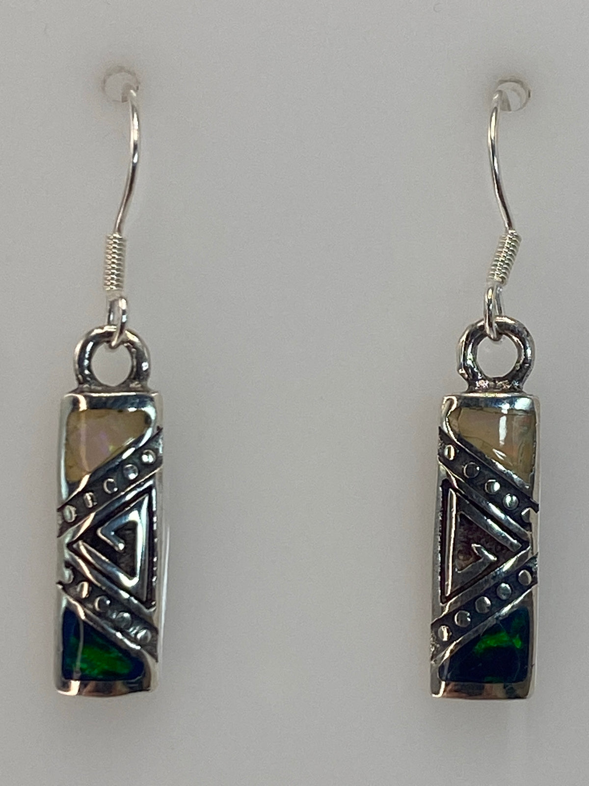 Par de aretes de plata con Opalo de Fuego azul y diseno geometrico, colgando