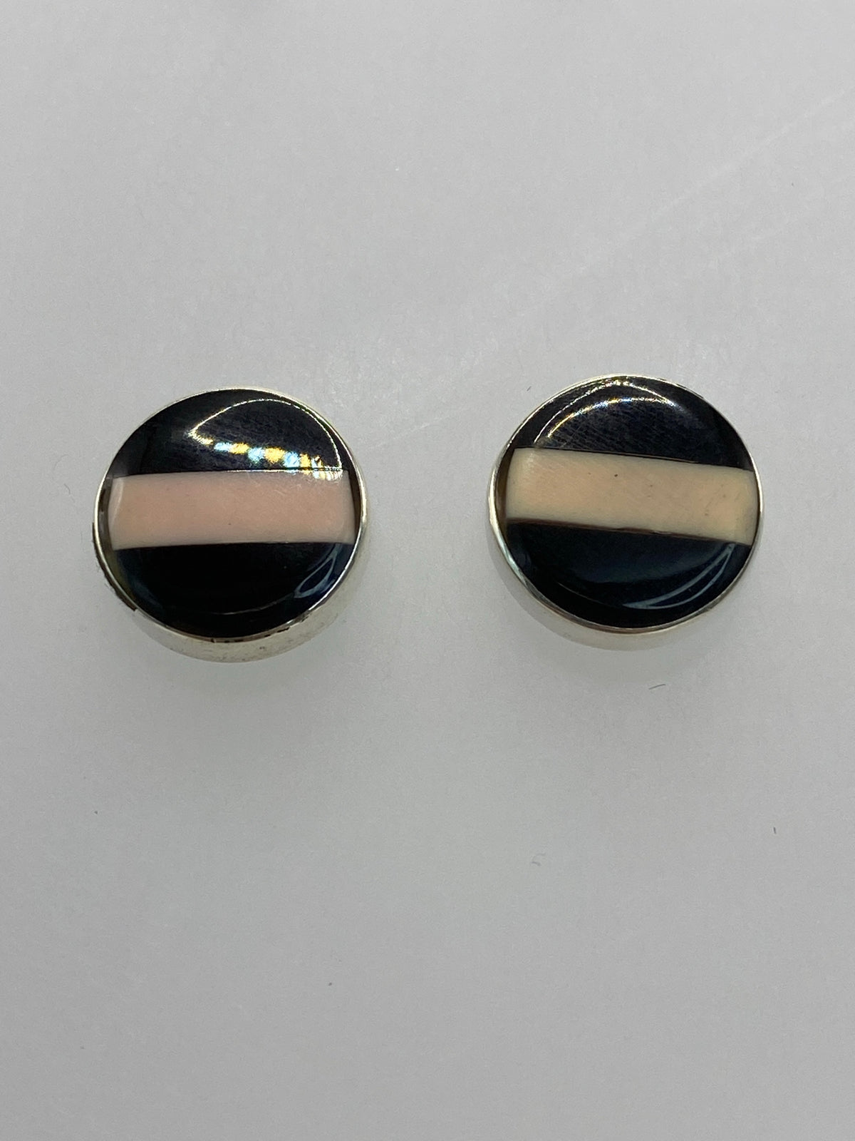 Detalle de la incrustación de piedra multicolor en ambos aretes