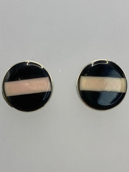 Aretes de plata con piedra multicolor en la oreja, mostrando el tamaño y brillo