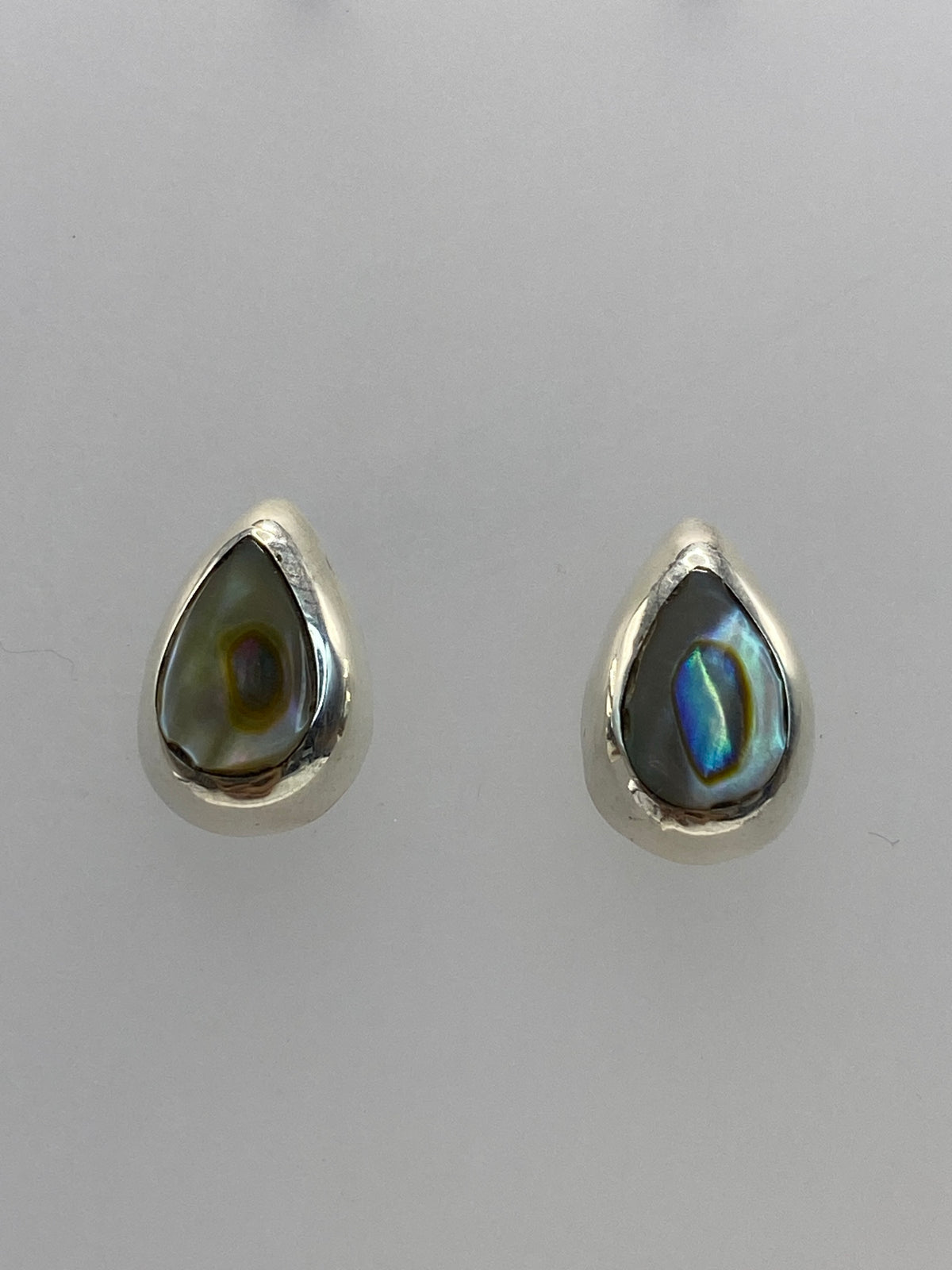 Detalle de la piedra multicolor con reflejos azules y dorados en cada arete