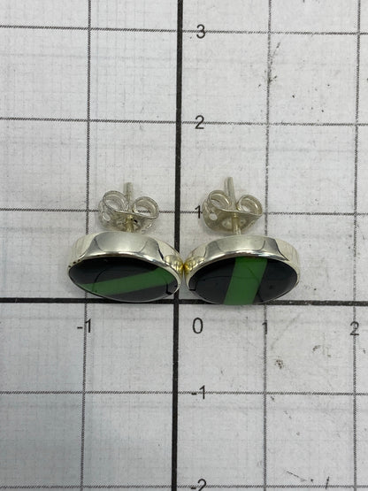 Aretes de plata 925 junto a moneda de peso mostrando escala