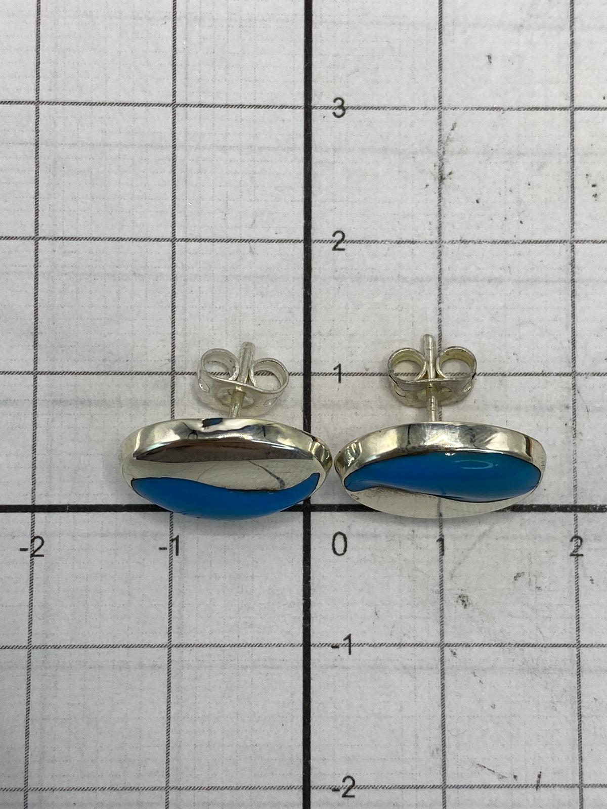 Par de aretes en la mano mostrando el peso ligero y la elegancia discreta