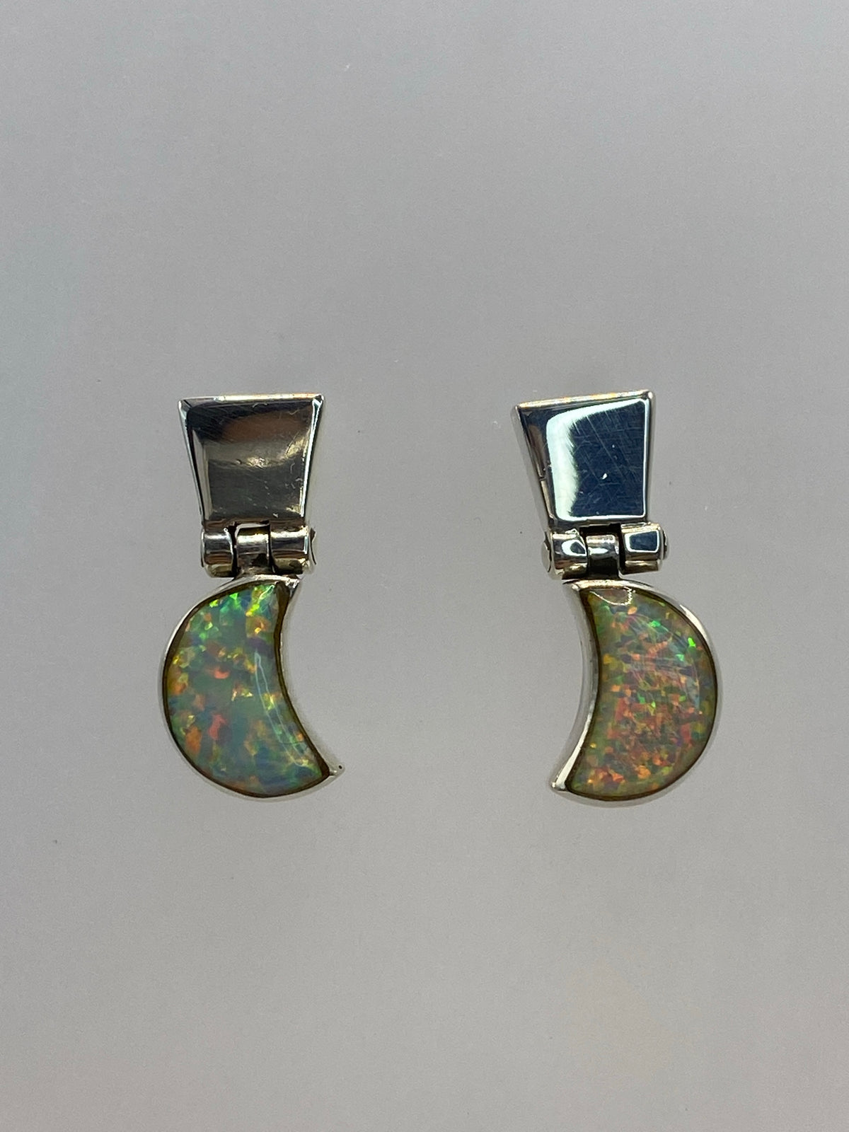 Detalle del ópalo de fuego multicolor engastado en plata, mostrando destellos de color