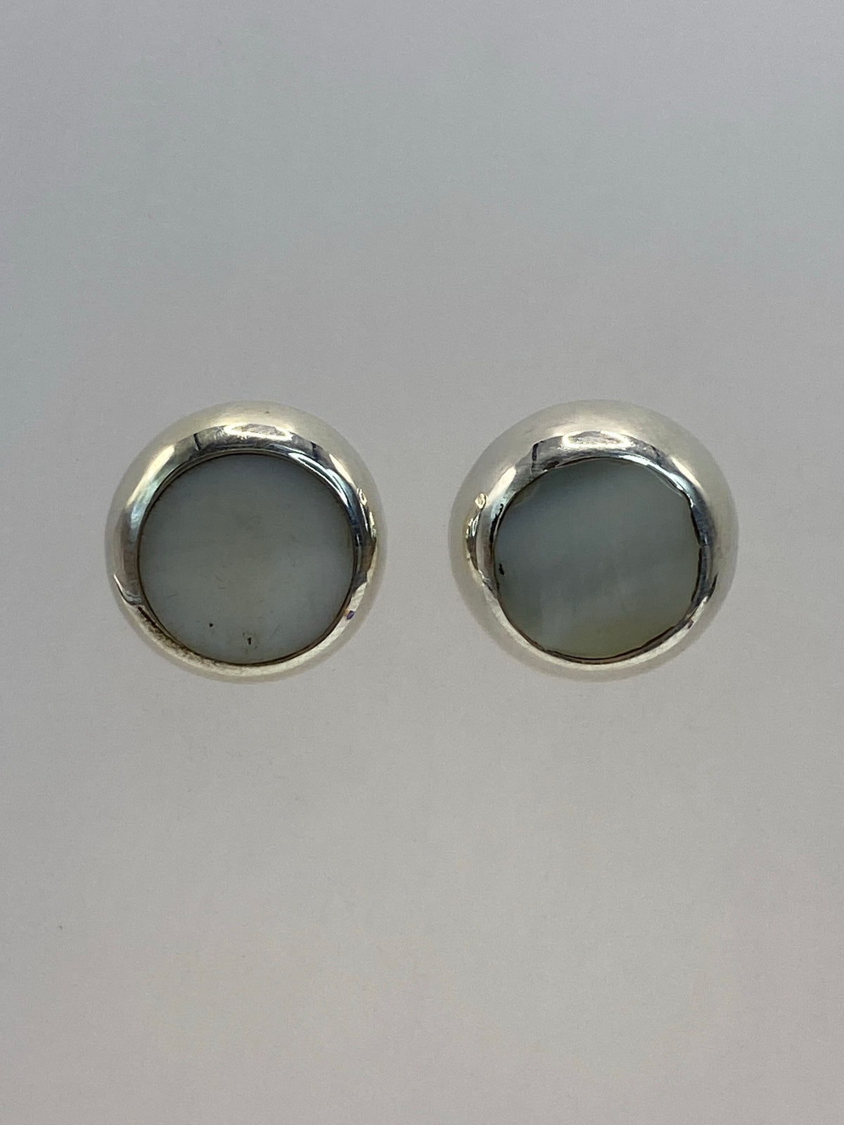 Aretes de plata 925 con piedra blanca redonda engastada, par completo visto de frente