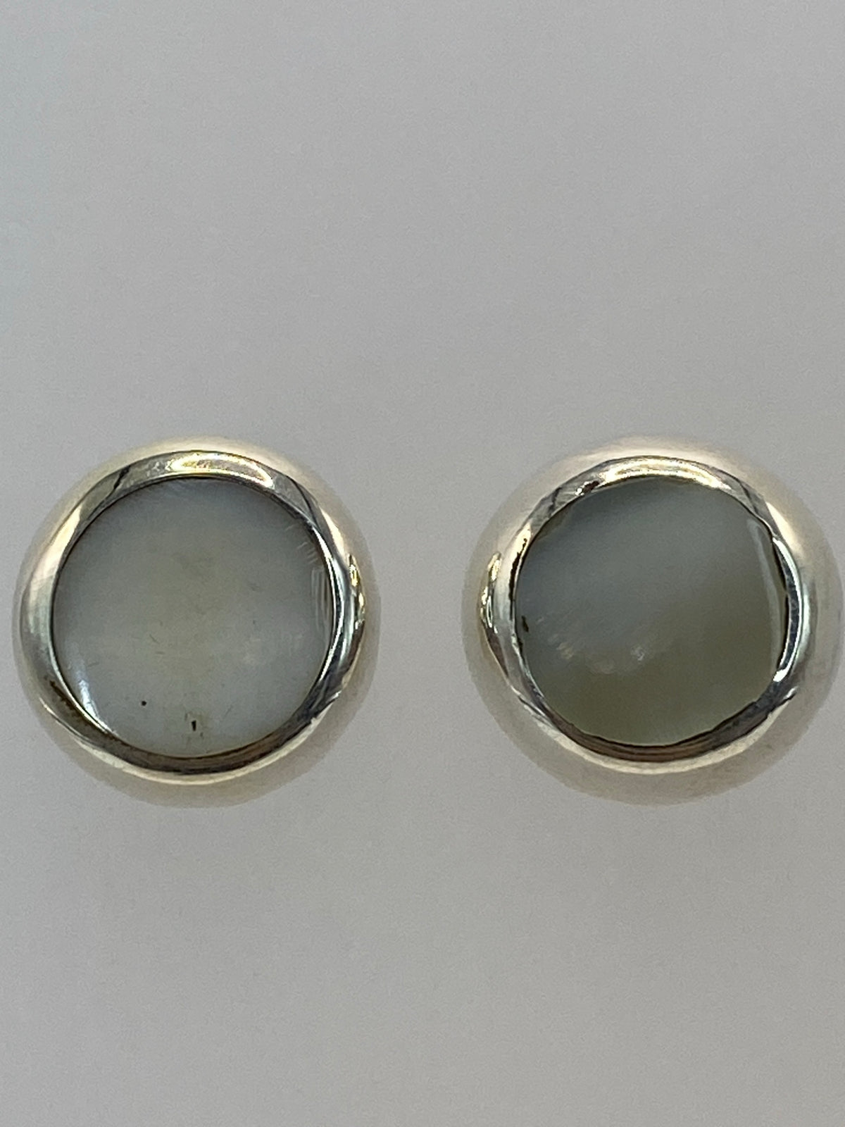 Aretes sobre regla de medición mostrando 1.4 cm de largo