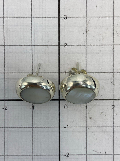 Par de aretes de plata colocados en balanza con peso de 2.6 gramos