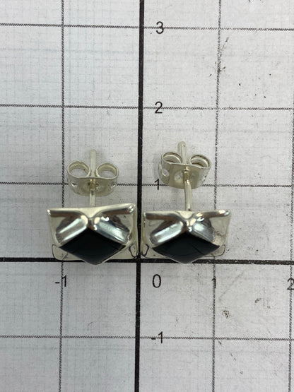 Vista lateral de los aretes destacando el trabajo de plata y la profundidad del diseño