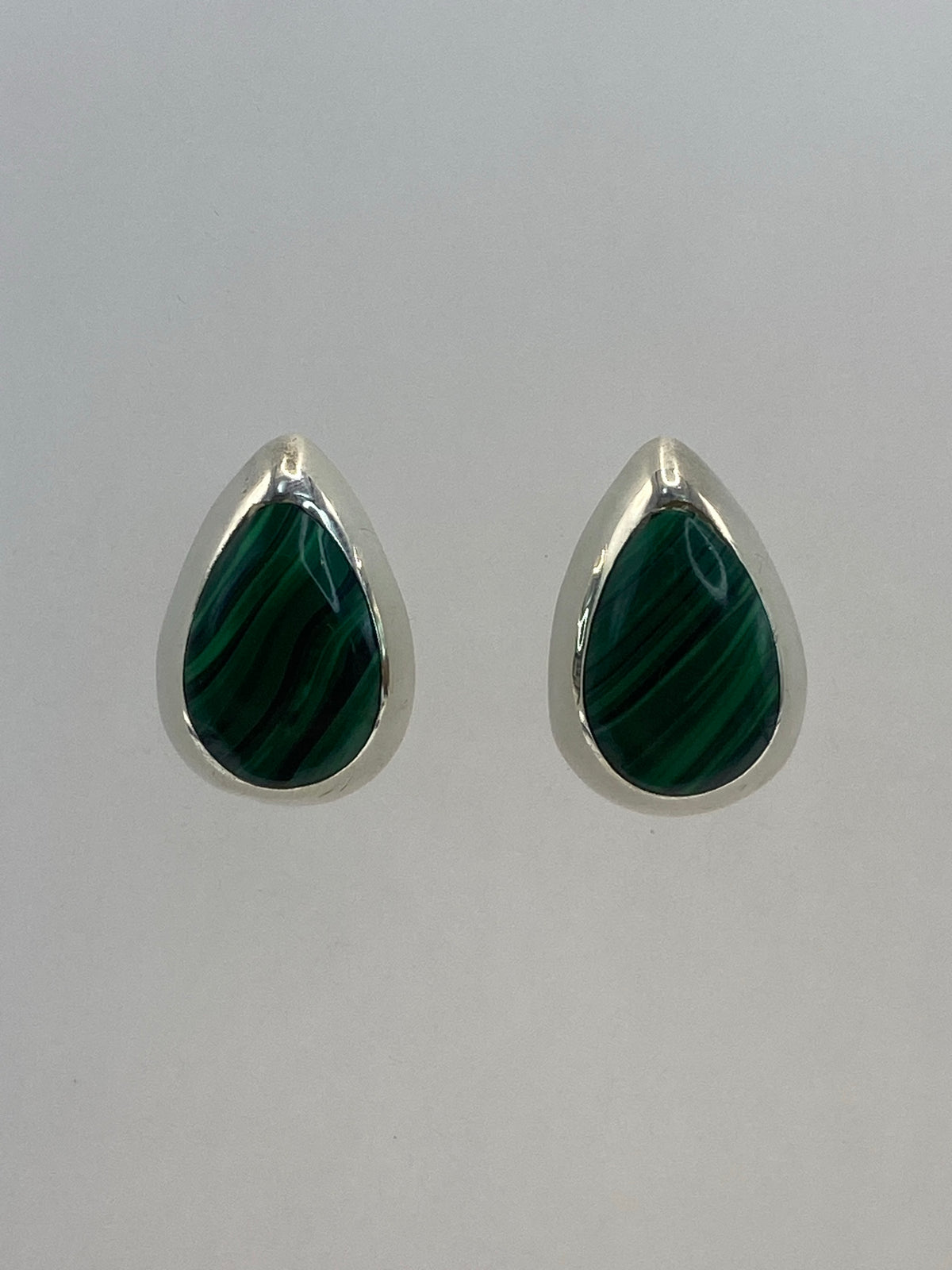 Par de aretes de plata 925 con piedra multicolor, sobre fondo neutral