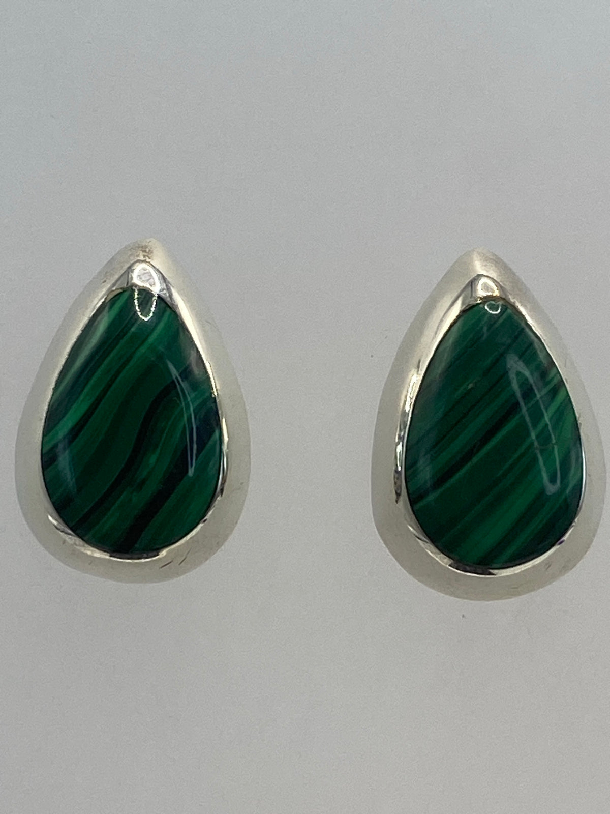 Vista lateral de los aretes con piedra brillante, fotografiados con regla de escala