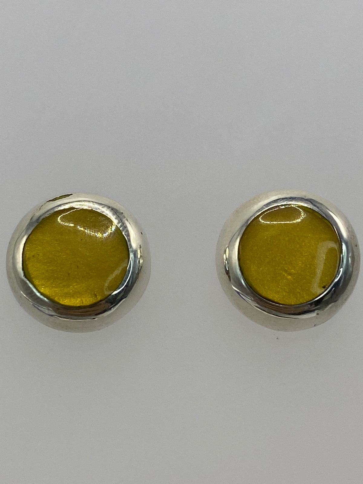 Aretes con piedra amarilla sobre fondo gris, mostrando el Quinto 925