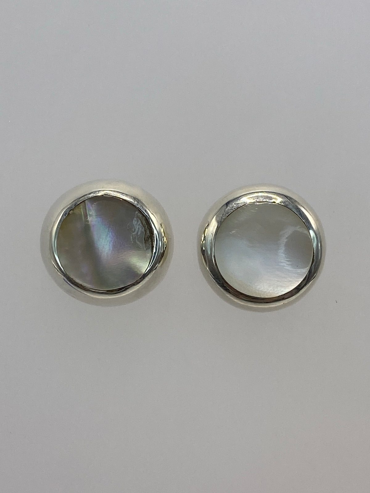 Aretes de plata con piedra multicolor sobre fondo blanco