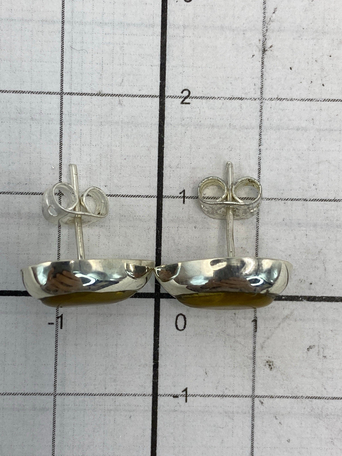 Aretes de plata sobre fondo blanco mostrando el Quinto 925