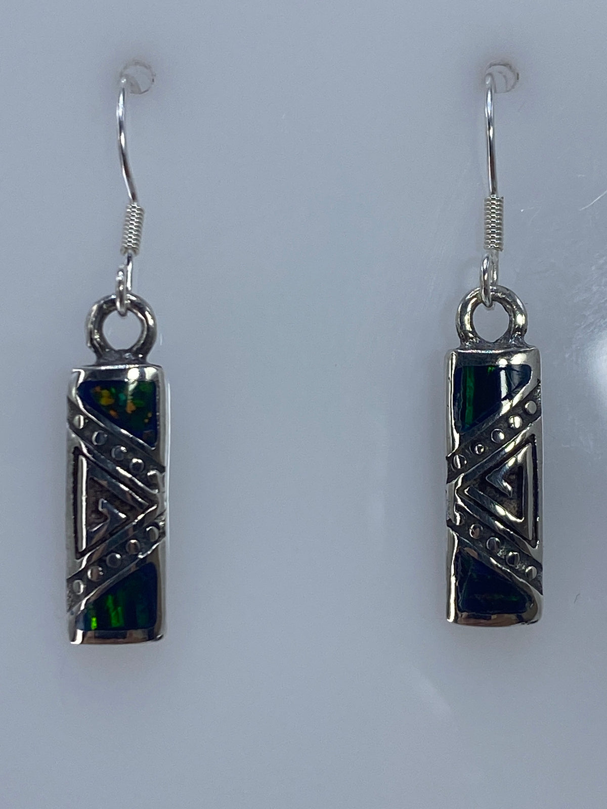 Par de aretes de plata con ópalo de fuego verde, diseño geométrico prehispánico, colgando de los ganchos