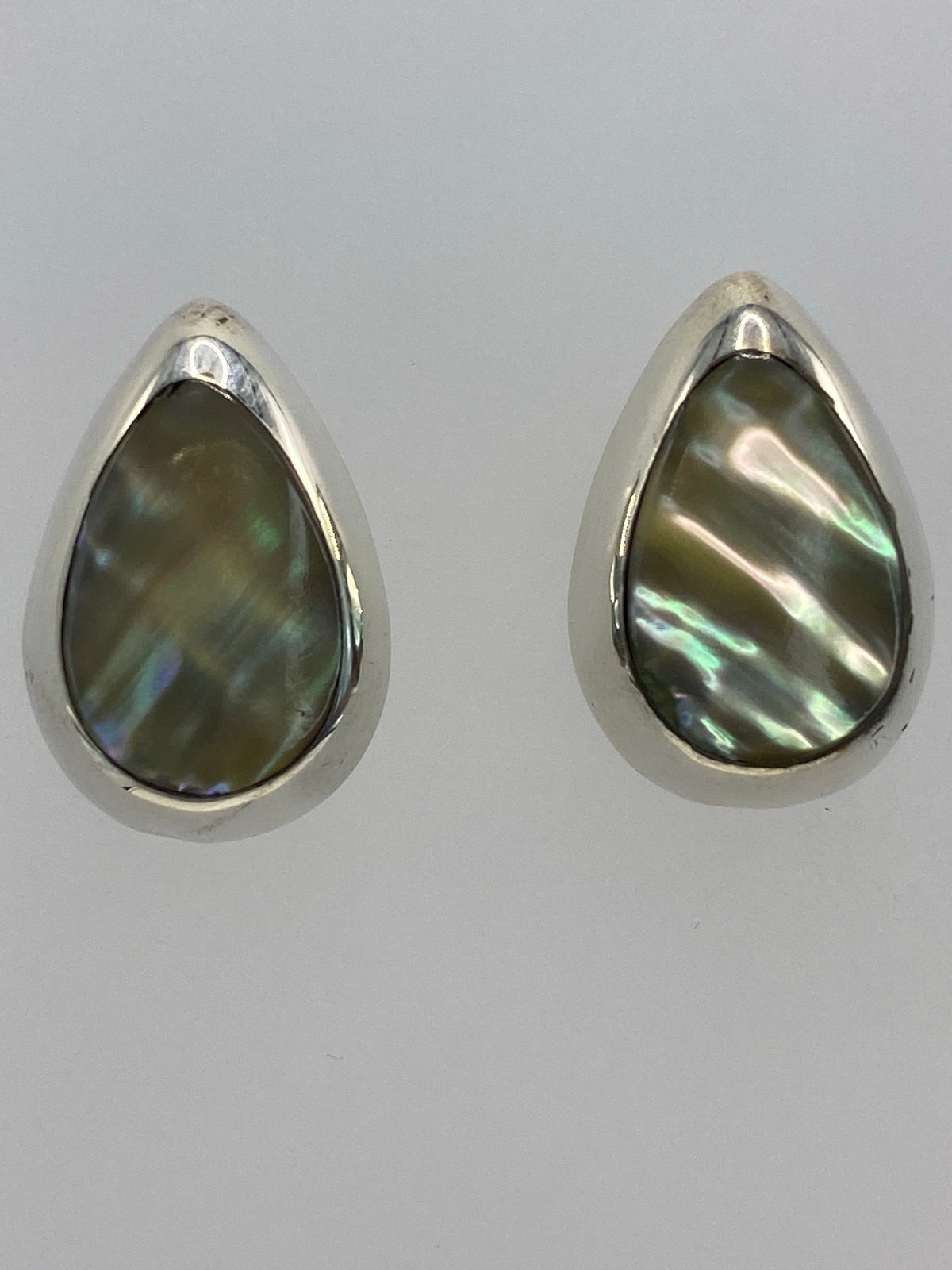 Vista lateral del par de aretes con piedra multicolor en plata Taxco