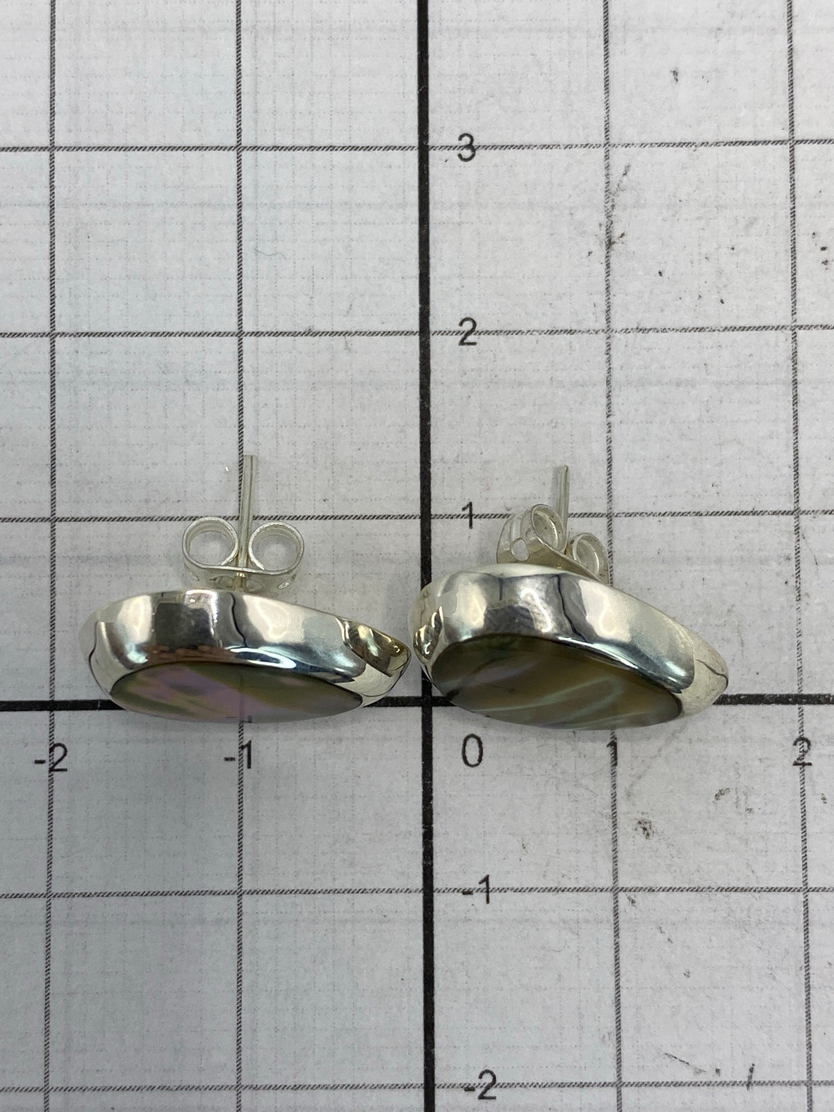 Aretes de plata sobre regla mostrando largo de 1.2 centímetros