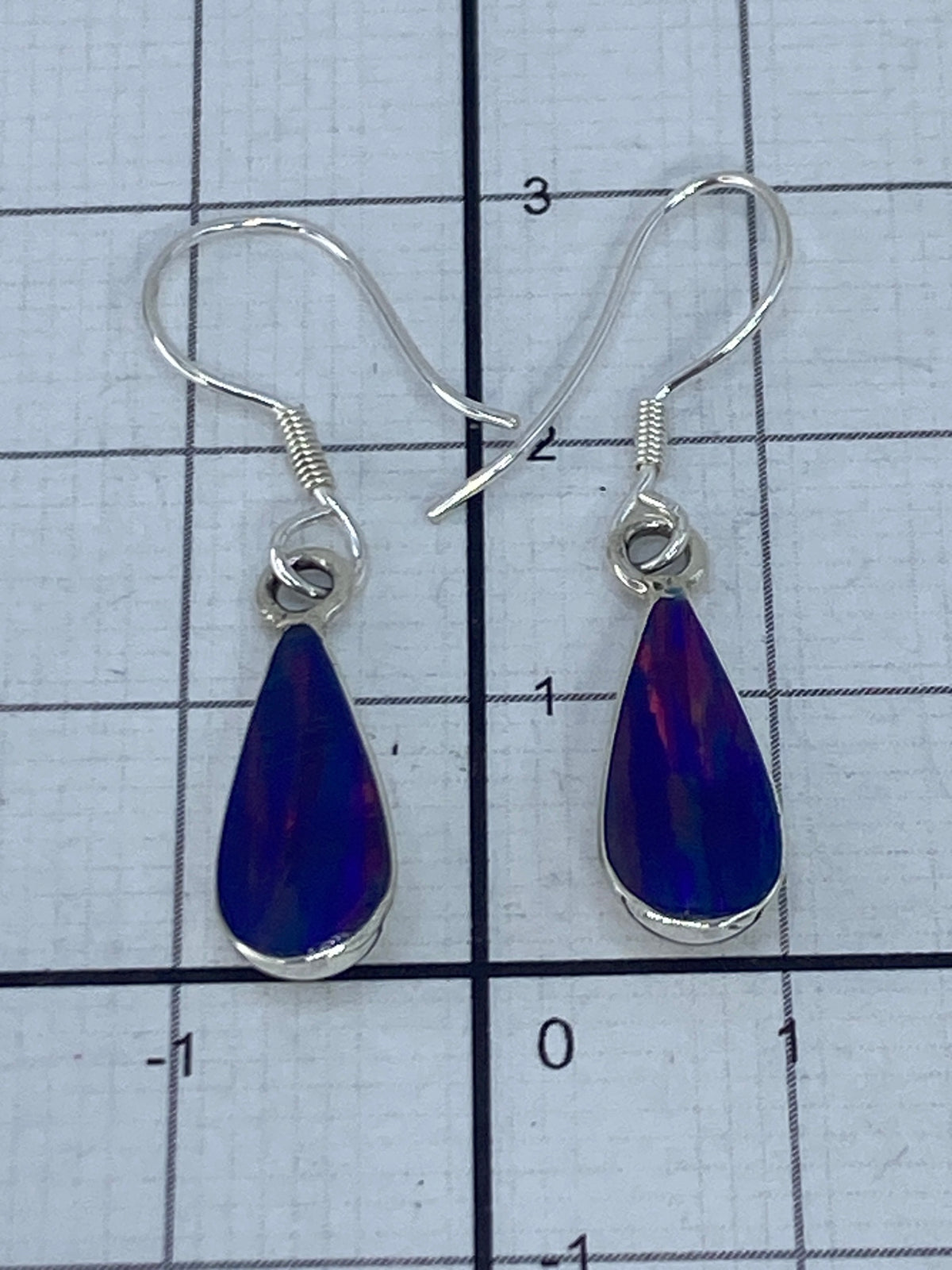 Aretes sobre regla mostrando medida de 3 cm