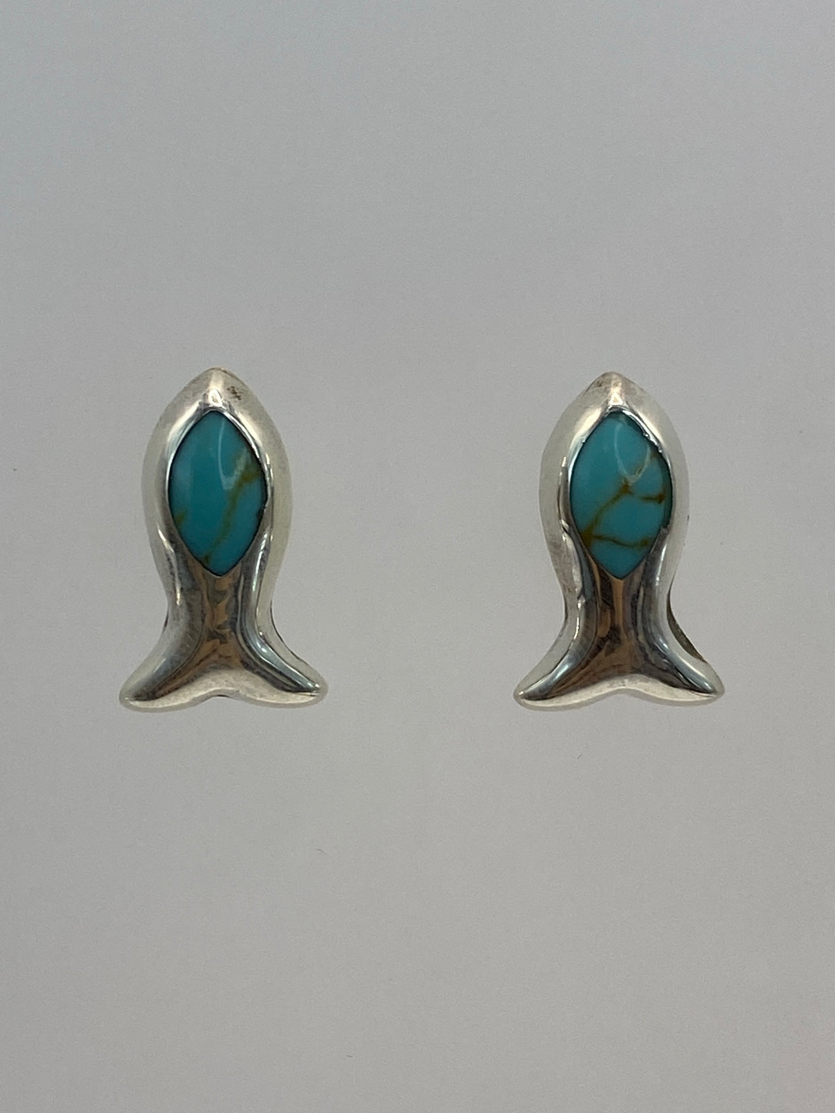 Par de aretes de plata 950 con turquesa azul cielo, tamaño minimalista, sobre fondo blanco