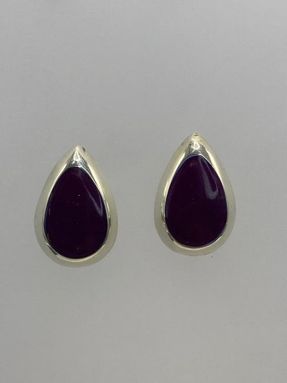 Aretes de plata 925 con piedra morada engastada, vistos de frente sobre fondo blanco