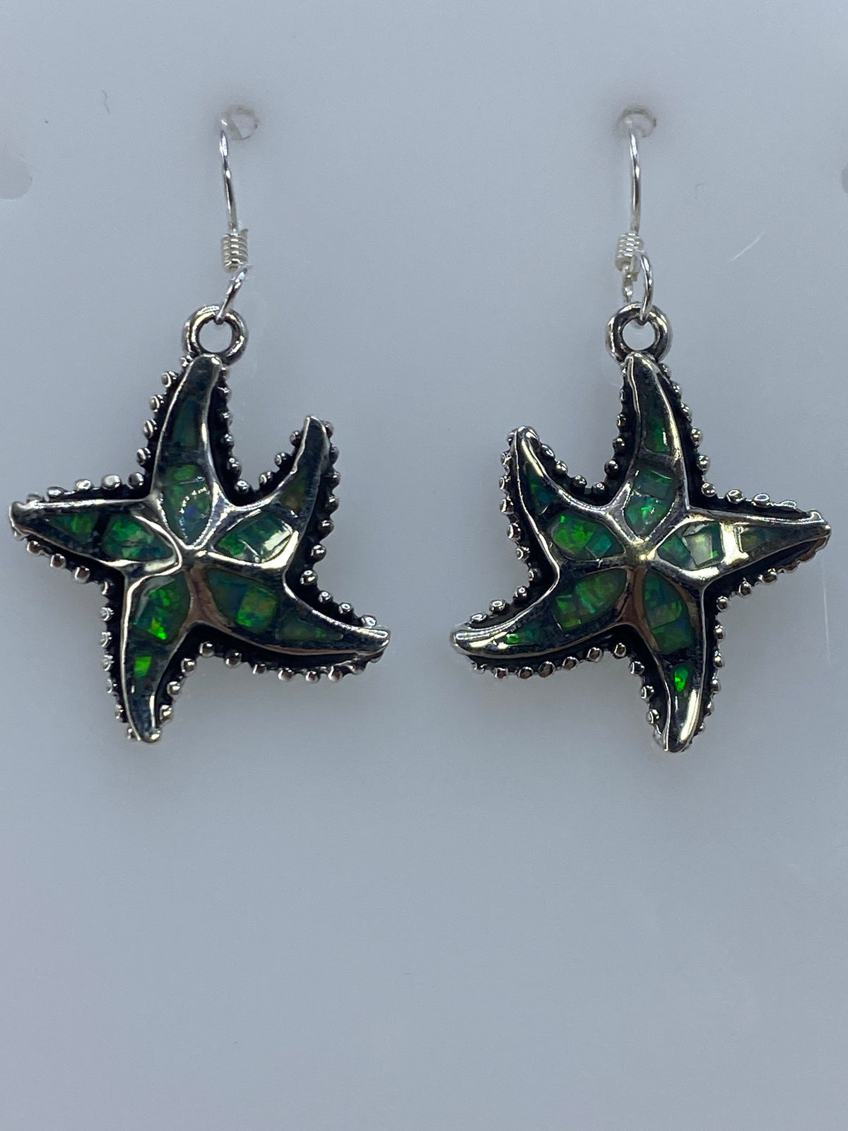 Par de aretes de plata con ópalo de fuego azul cielo, engaste a mano, vistos de frente