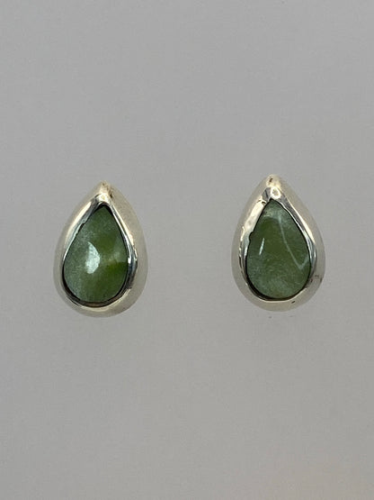 Par de aretes de plata con piedra verde engastada, forma de gota, sobre fondo blanco