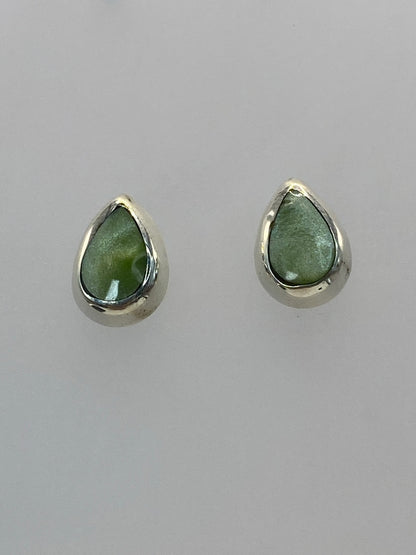Detalle frontal de los dos aretes mostrando la piedra natural y el engaste de plata