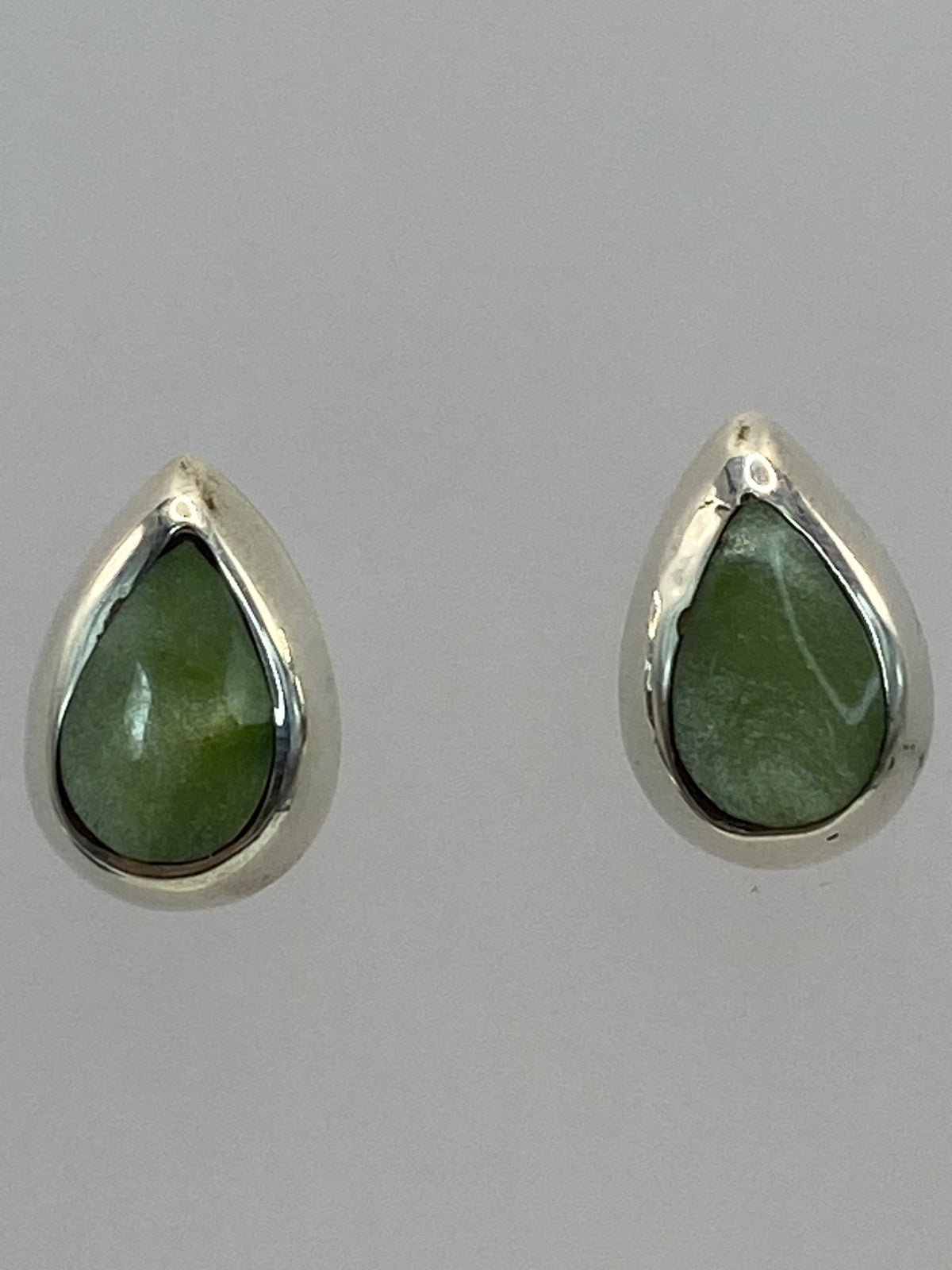 Aretes de costado en la mano para escala de tamaño (1.3 cm de largo)