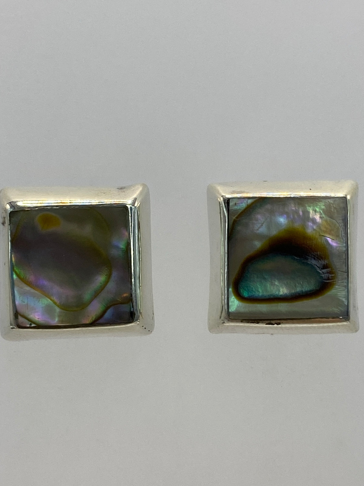 Aretes colocados sobre fondo blanco con la marca 925 visible