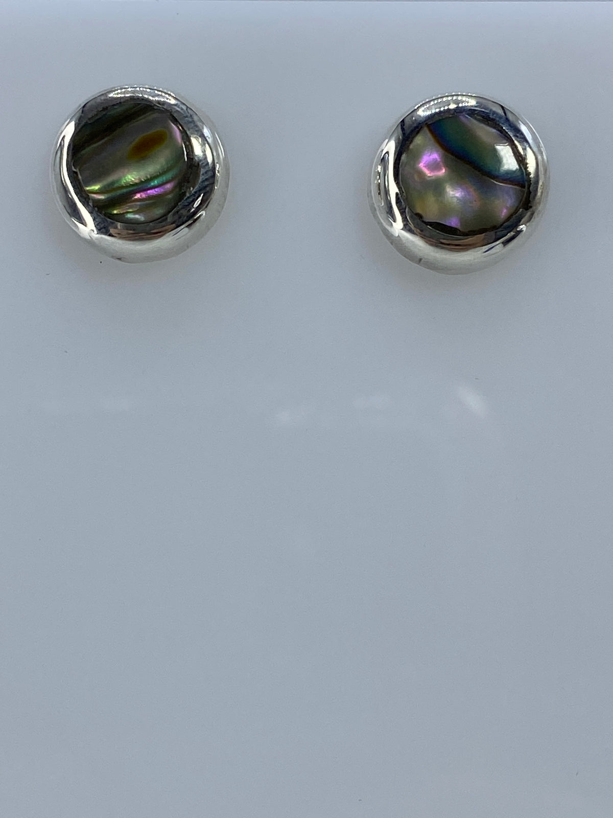 Detalle de las piedras multicolor brillando en los aretes de plata