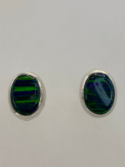Aretes colocados en las orejas mostrando el tamaño delicado de 1.4 cm