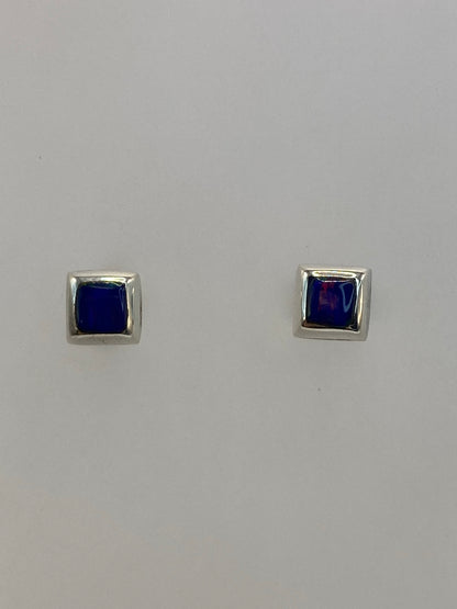 Par de aretes de plata 950 con ópalo de fuego azul, broche de tuerca, sobre fondo blanco