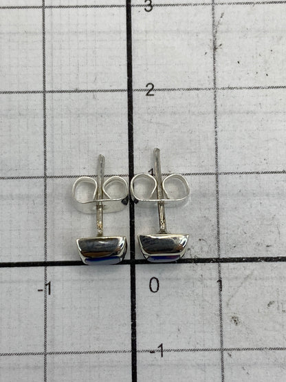 Los aretes en la balanza mostrando el peso de 0.8 g y el Quinto 950