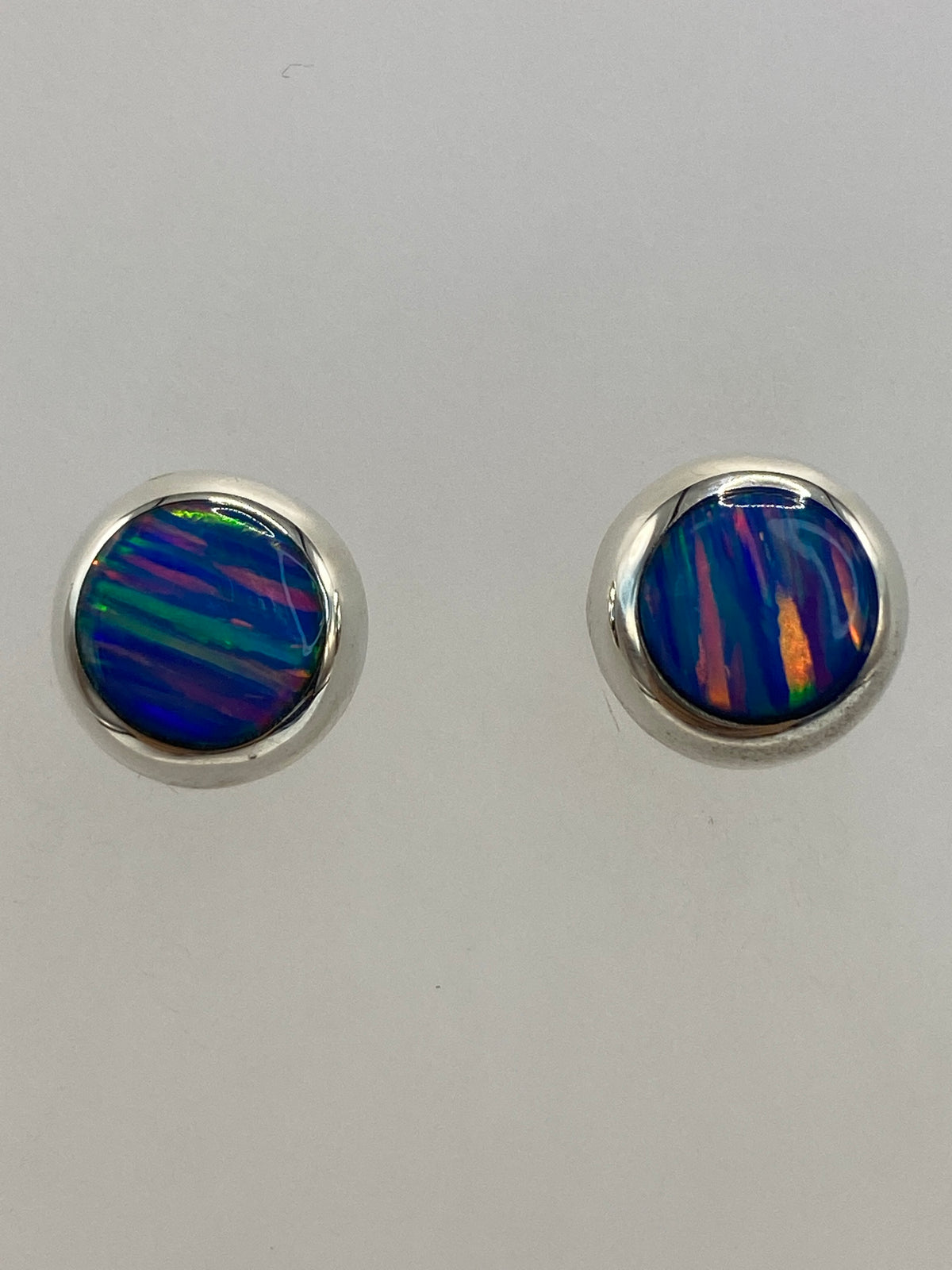 Aretes de ópalo de fuego en postes de plata 925, junto a regla mostrando 1.3 cm de largo