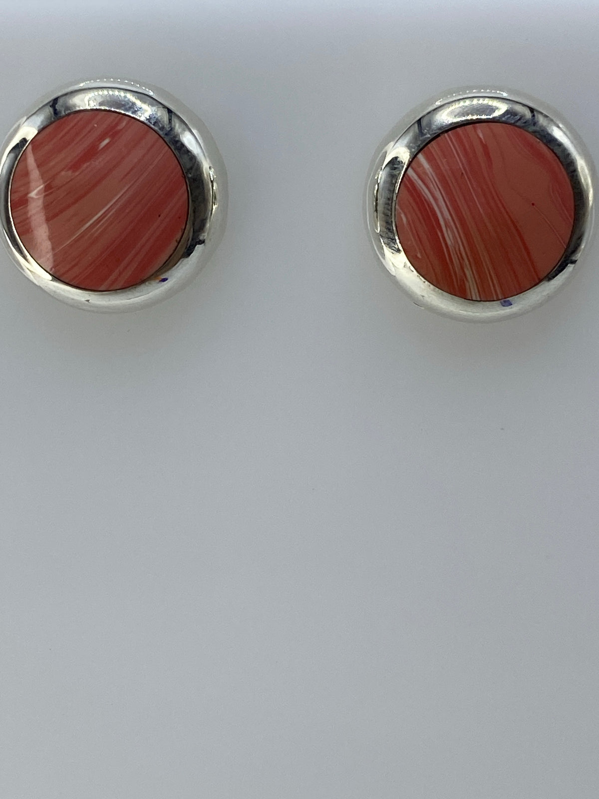 Aretes en la mano mostrando tamaño delicado de 1.2 cm
