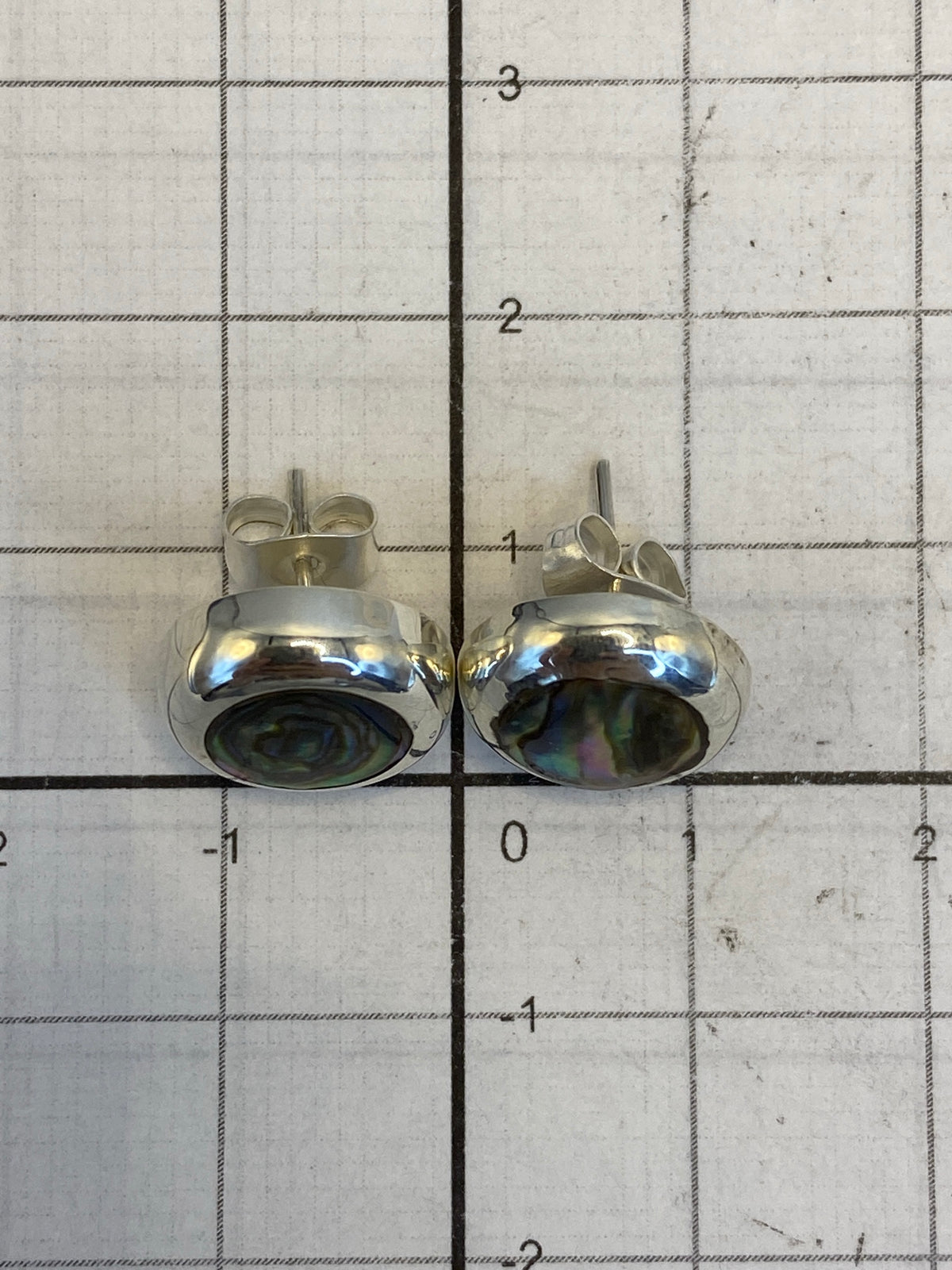 Aretes sobre fondo blanco mostrando el acabado pulido y el Quinto 925