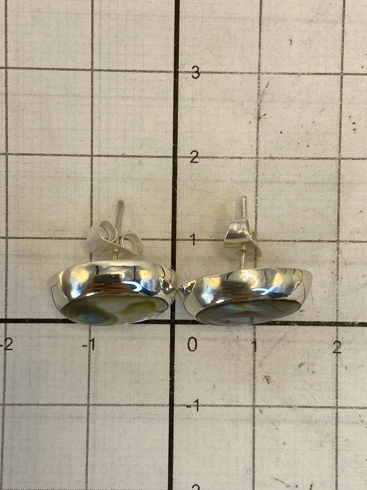 Aretes colocados en escala de centímetros para mostrar su tamaño de 1.4 cm