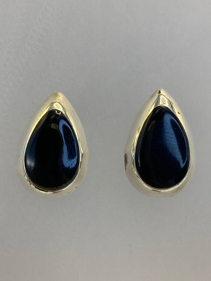 Par de aretes de plata con onix negro pulido, vista frontal mostrando el tamaño compacto