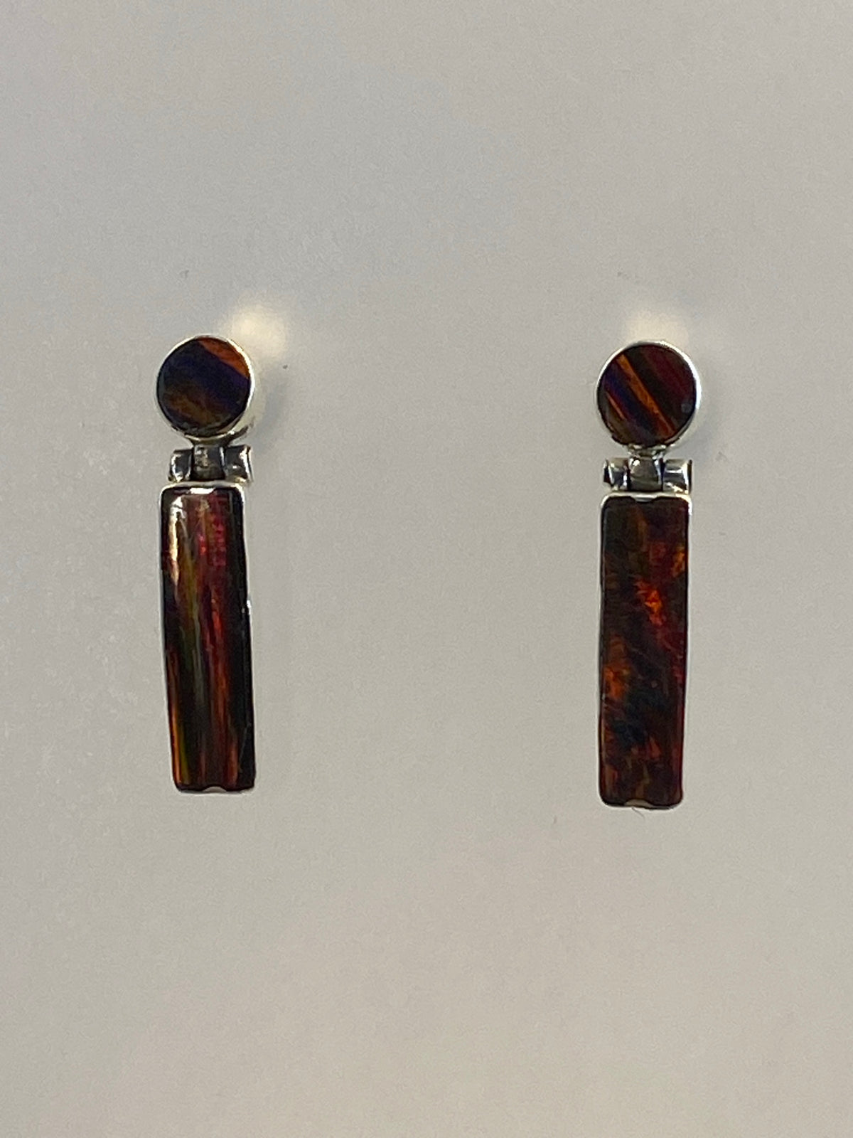 Par de aretes de plata 950 con Opalo de Fuego rojo, vistos de frente sobre fondo blanco