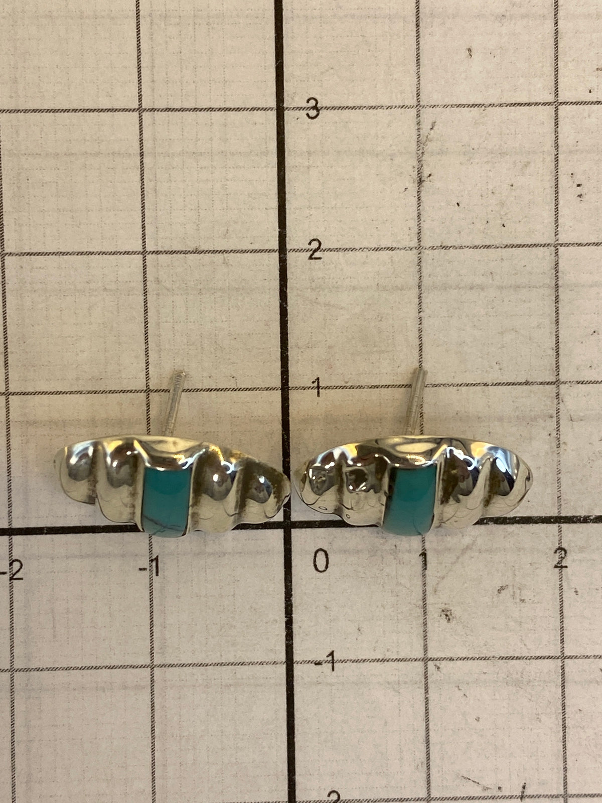 Comparación de tamaño: aretes de turquesa al lado de una regla mostrando 1.2 cm de largo