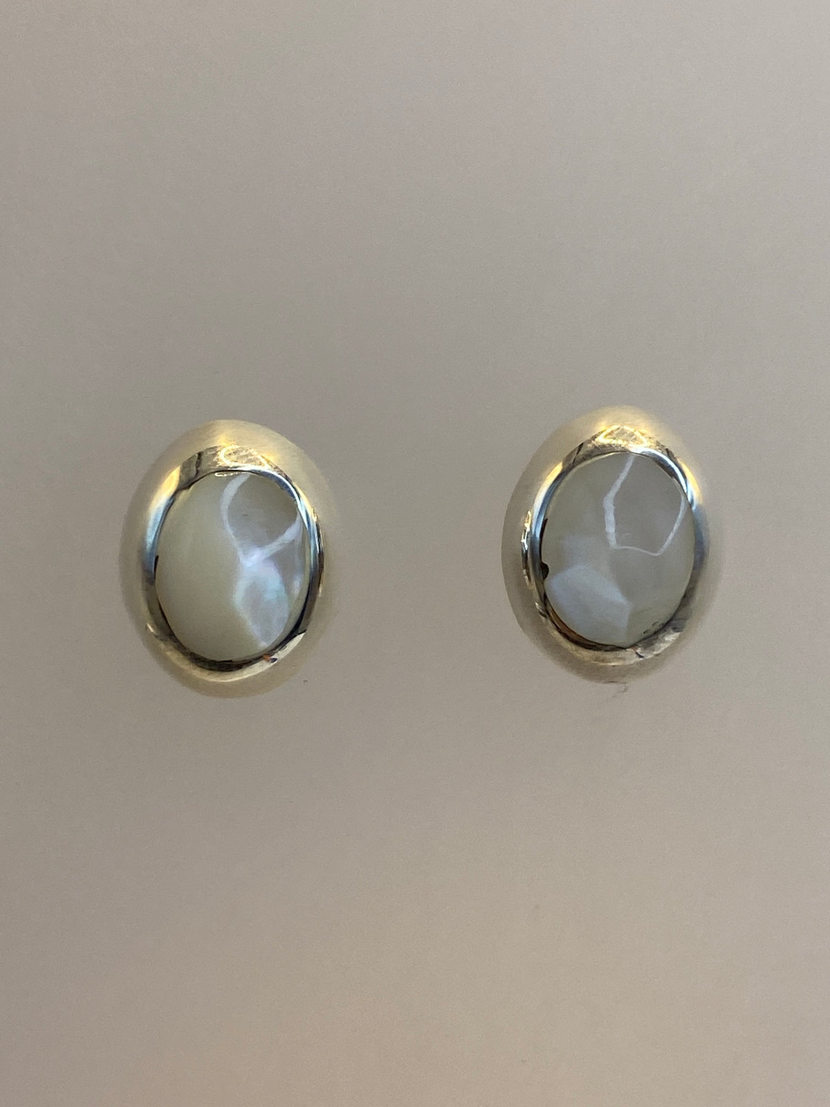Aretes de plata 925 con piedra engastada a mano, ligeramente curvados, mostrando el brillo del metal