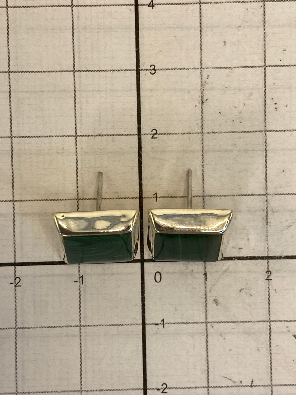 Aretes en la mano mostrando el tamaño real de 1.3 cm