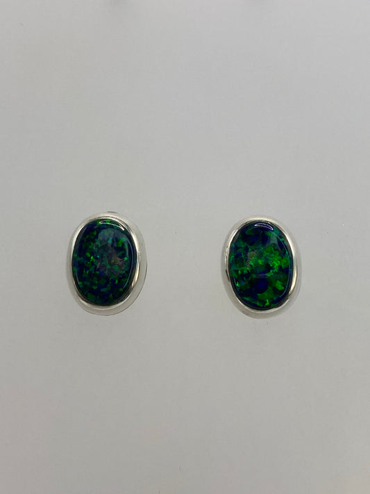 Par de aretes de plata 925 con ópalo de fuego verde, vista frontal reflejando la luz