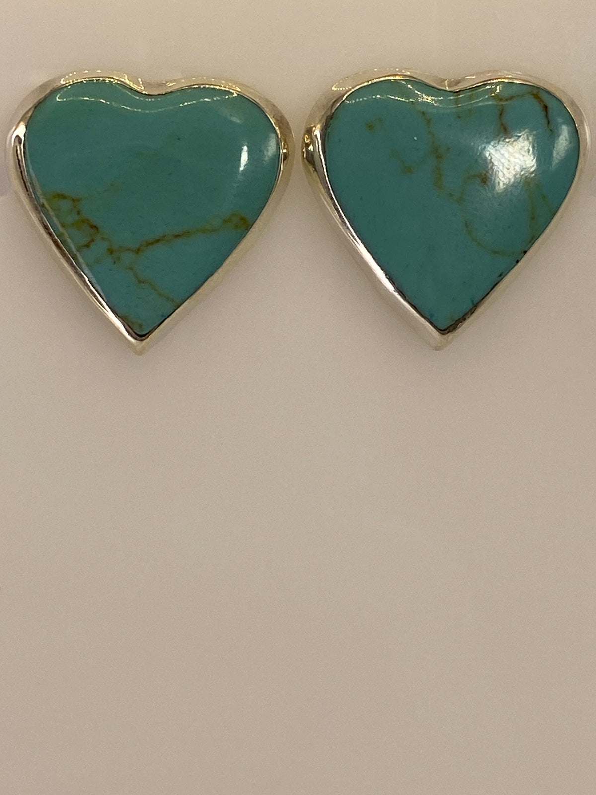 Par de aretes de plata 925 con turquesa azul cielo, incrustación artesanal, vista frontal sobre fondo blanco