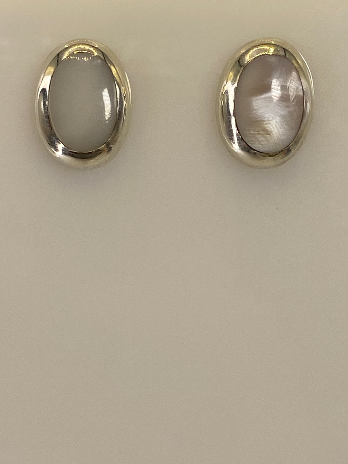 Par de aretes de plata 925 con piedra multicolor sobre fondo blanco, vista frontal