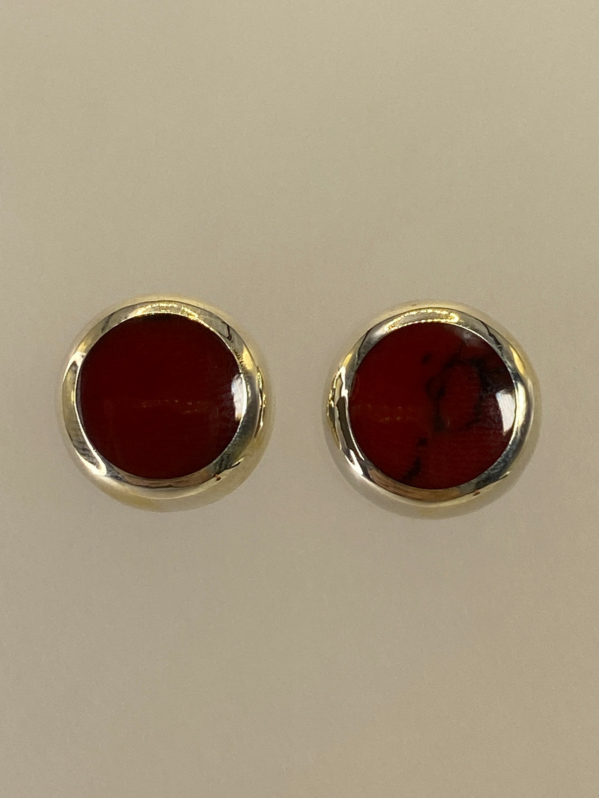 Aretes de plata con piedra roja engastada, 1.4 cm, sobre fondo blanco