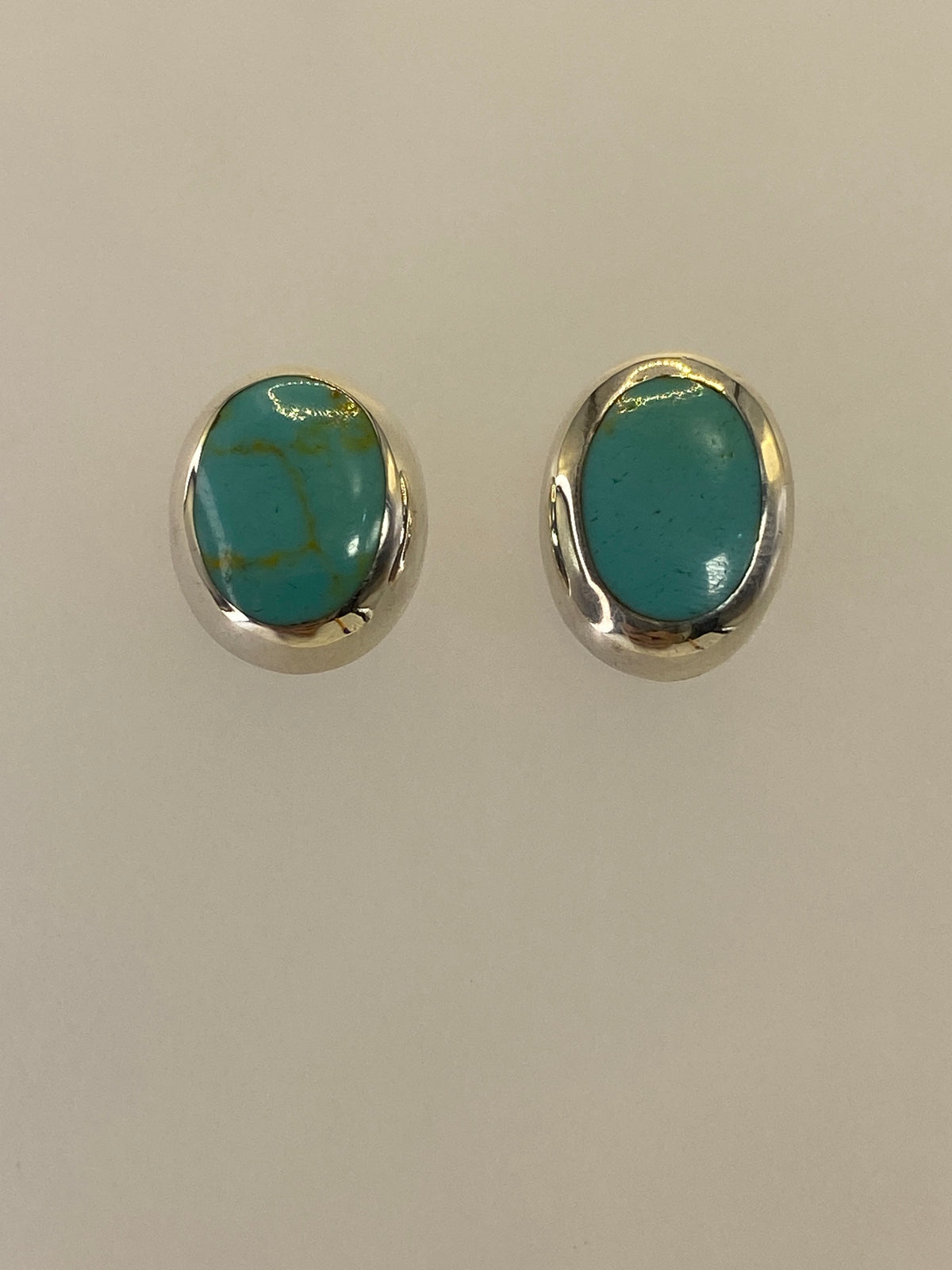 Arete individual mostrando la turquesa azul verdosa y café con engaste de plata